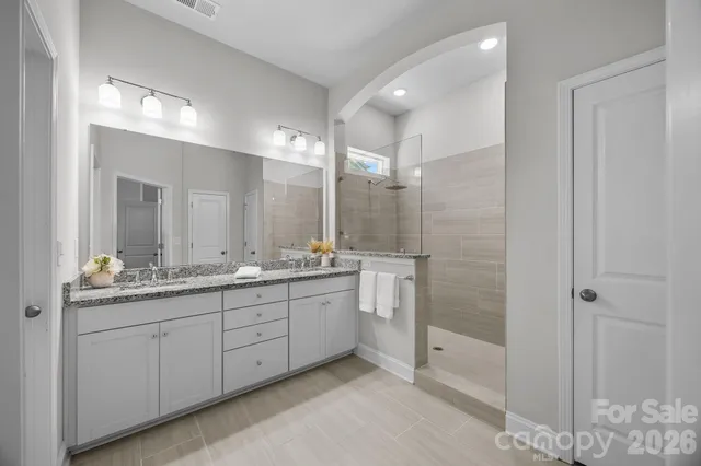 a bathroom with a granite countertop sink a toilet and shower