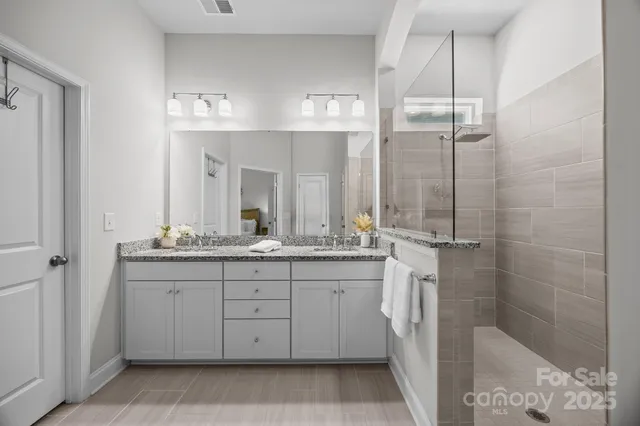 a bathroom with a granite countertop sink a mirror and a shower