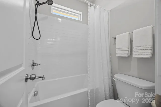 a bathroom with a toilet and a bath tub