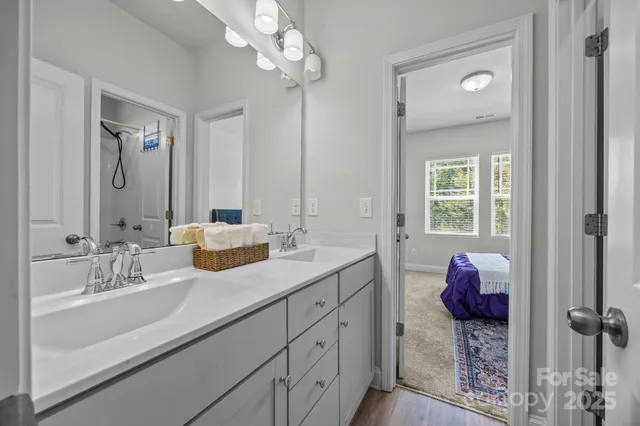 a en suite bathroom with double vanity and a mirror