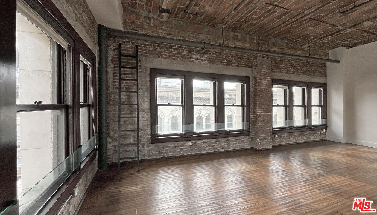 460 South Spring Street, Unit 1211 Los Angeles, CA 90013 - Photo 14 of 26 an empty room with wooden floor and windows