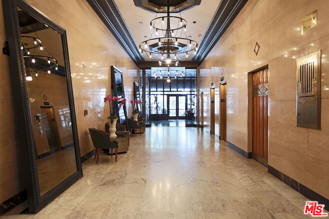 460 South Spring Street, Unit 1211 Los Angeles, CA 90013 - Photo 18 of 26 a view of a hallway with couches and chandelier