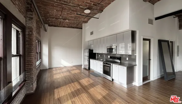 a kitchen with stainless steel appliances granite countertop a refrigerator and a stove top oven