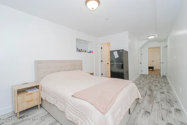 a spacious bedroom with a bed and a refrigerator