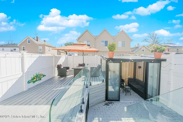 a view of a patio with a table and chairs under an umbrella