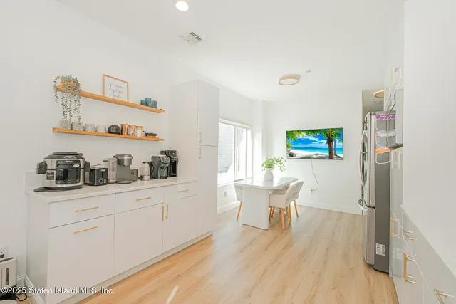 a kitchen with stainless steel appliances white cabinets and wooden floor