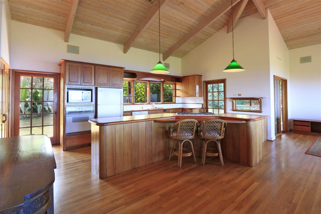 13434 Kula Highway Kula, HI 96790 - Photo 4 of 30 a kitchen with stainless steel appliances wooden floors stove refrigerator and dining table