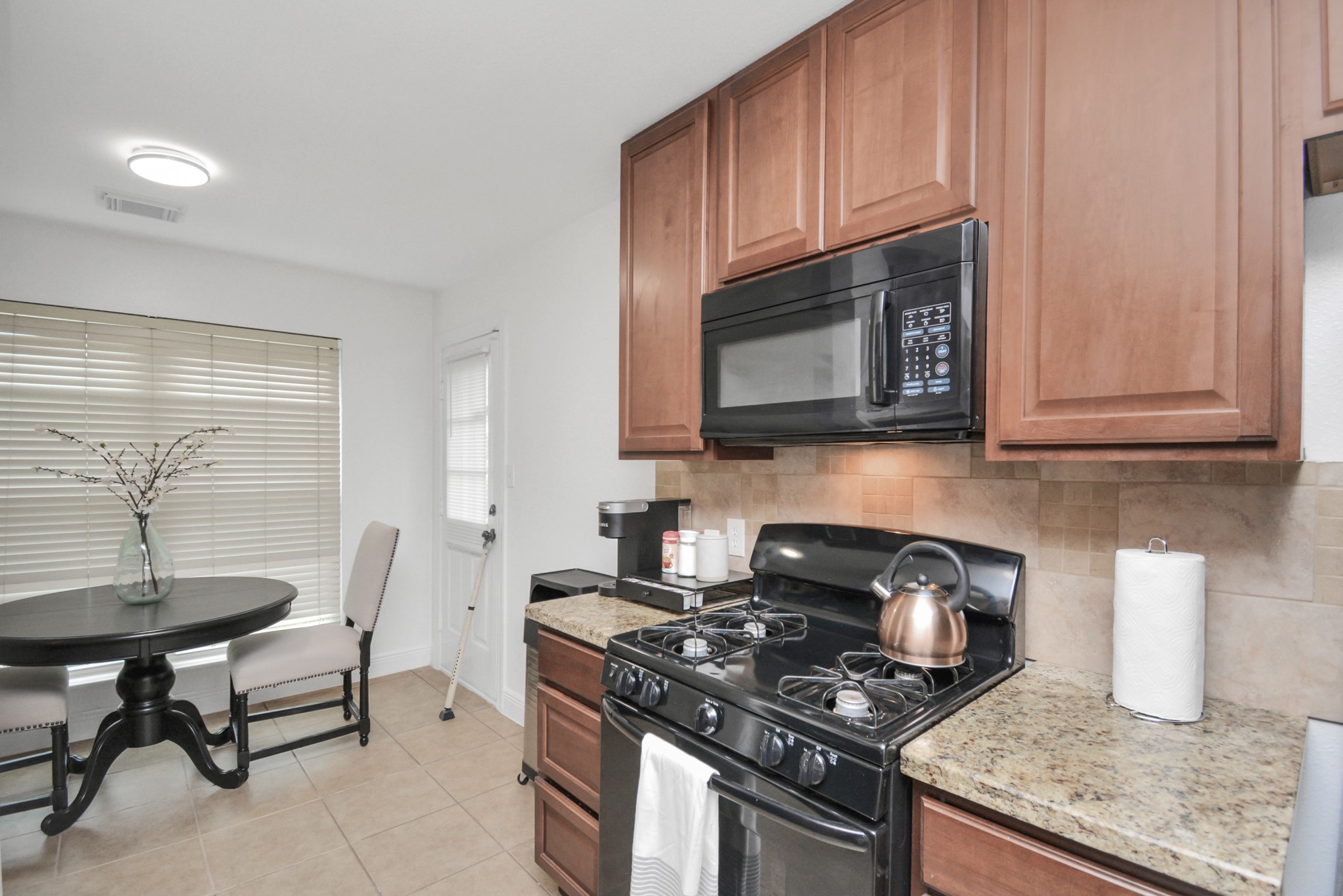 7830 Pardee Street Houston, TX 77028 - Photo 8 of 24 a kitchen with granite countertop a stove top oven microwave and cabinets