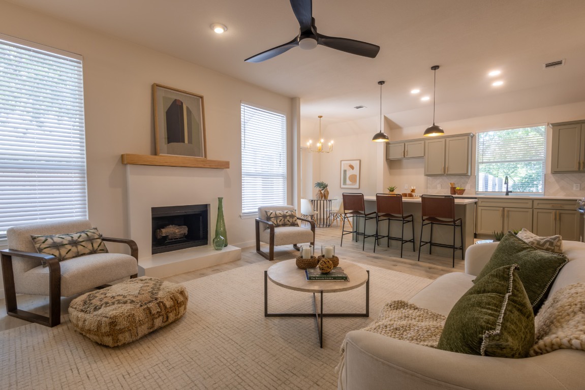 3000 Warwick Way Austin, TX 78748 - Photo 1 of 1 Living room featuring light wood-style flooring, recessed lighting, a fireplace with raised hearth, ceiling fan, and a chandelier