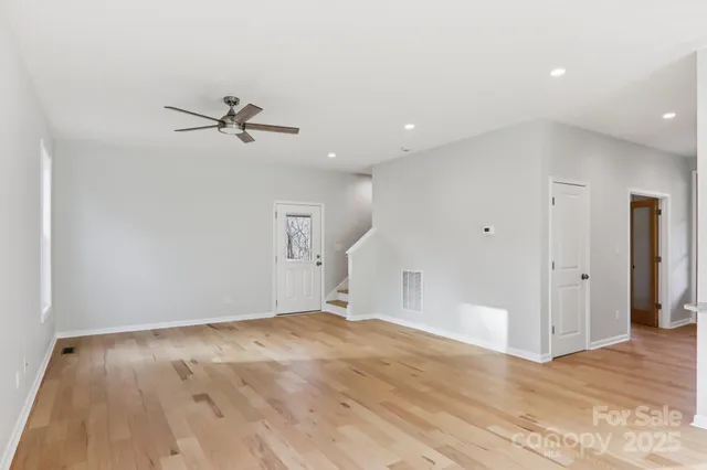 a view of room with wooden floor and ceiling fan