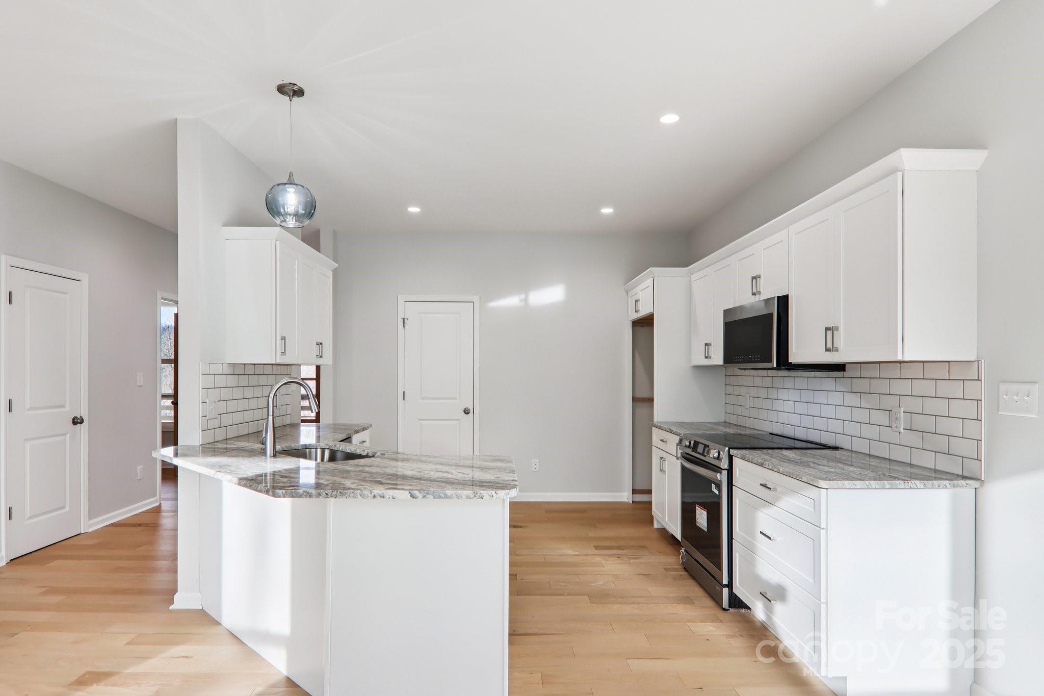119 Lincoln Rdg Drive, Unit 1 Candler, NC 28715 - Photo 15 of 44 a large kitchen with stainless steel appliances kitchen island granite countertop a lot of counter space and wooden floor