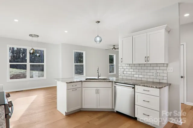 a kitchen with white cabinets and sink