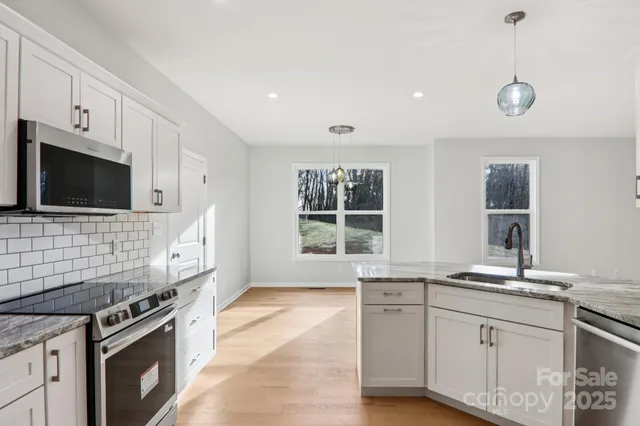 a kitchen with granite countertop cabinets stainless steel appliances and a sink
