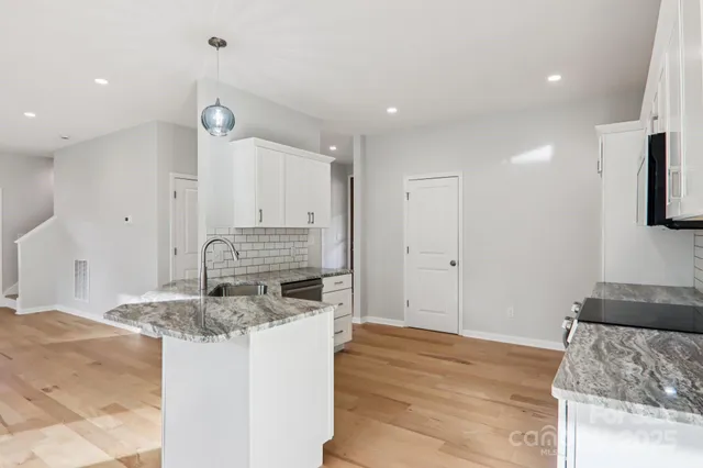a kitchen with stainless steel appliances granite countertop a sink and a stove