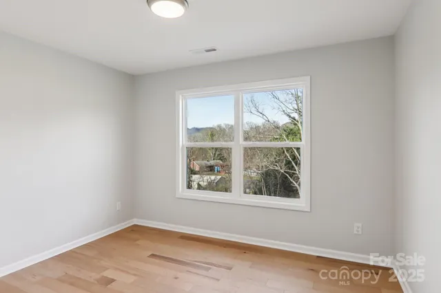 a kitchen with white cabinets and window