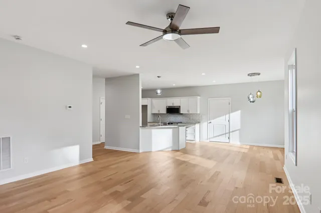a view of kitchen with stainless steel appliances wooden floor