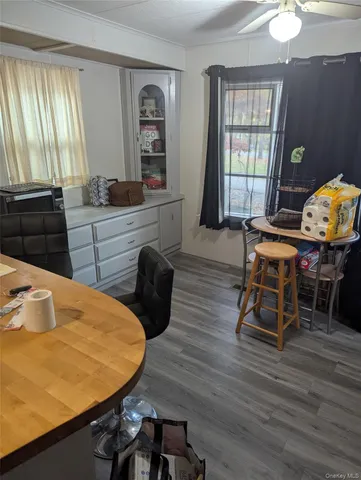 a room with wooden floor table and windows
