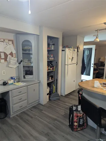 a room with a refrigerator and a dresser