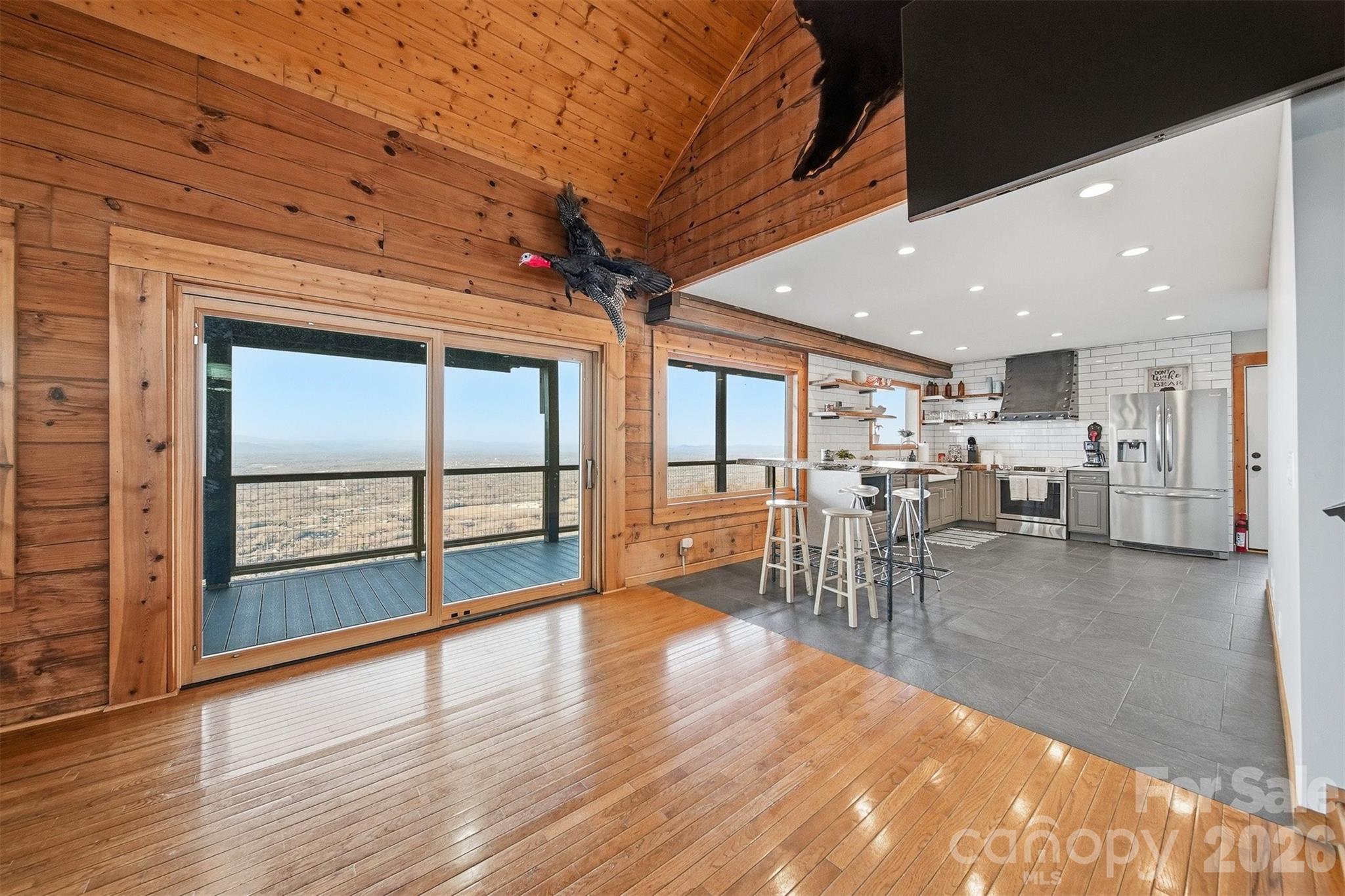 6500 Burkemont Road Morganton, NC 28655 - Photo 11 of 48 a dining room with wooden floor a ceiling fan and windows