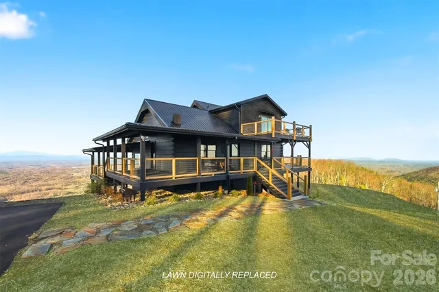 a view of a house with a big yard and large trees