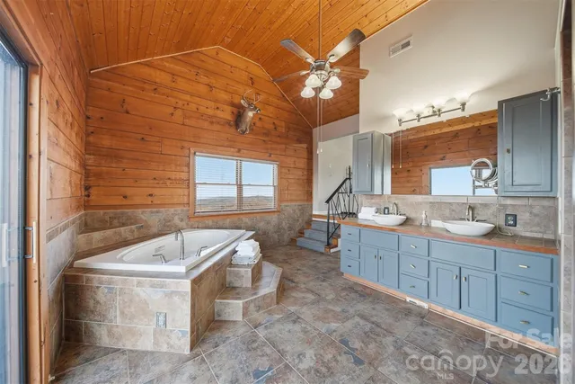 a spacious bathroom with a tub sink and mirror