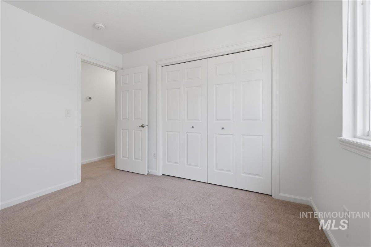 2075 North Springland Place Boise, ID 83713 - Photo 30 of 49 Carpeted room featuring a double bi-fold closet, a single window, and a paneled door