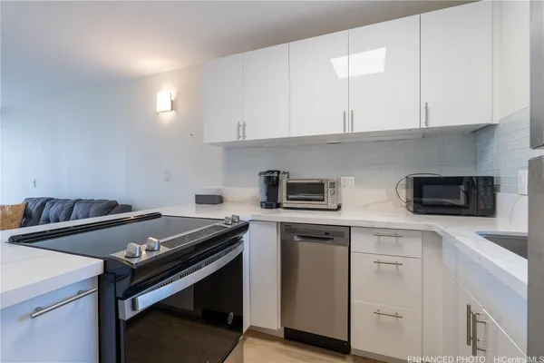a kitchen with cabinets appliances a sink and a counter space