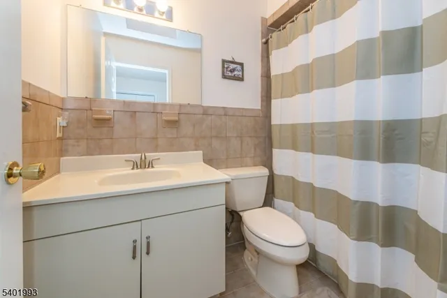 a bathroom with a sink a toilet and shower curtain