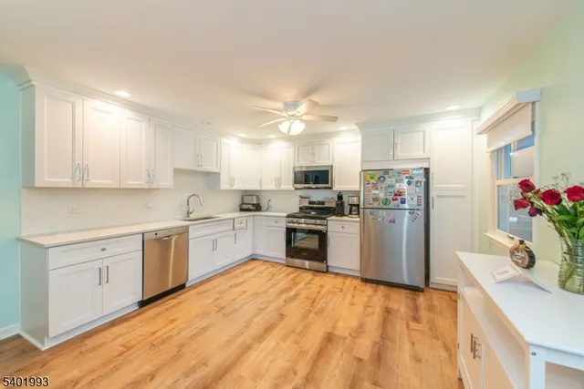 a kitchen with granite countertop a sink cabinets stainless steel appliances and a center island