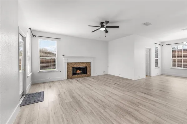 a view of empty room with wooden floor and fireplace