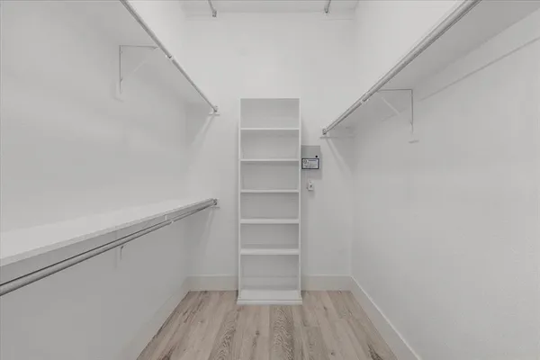 a view of walk in closet with empty racks