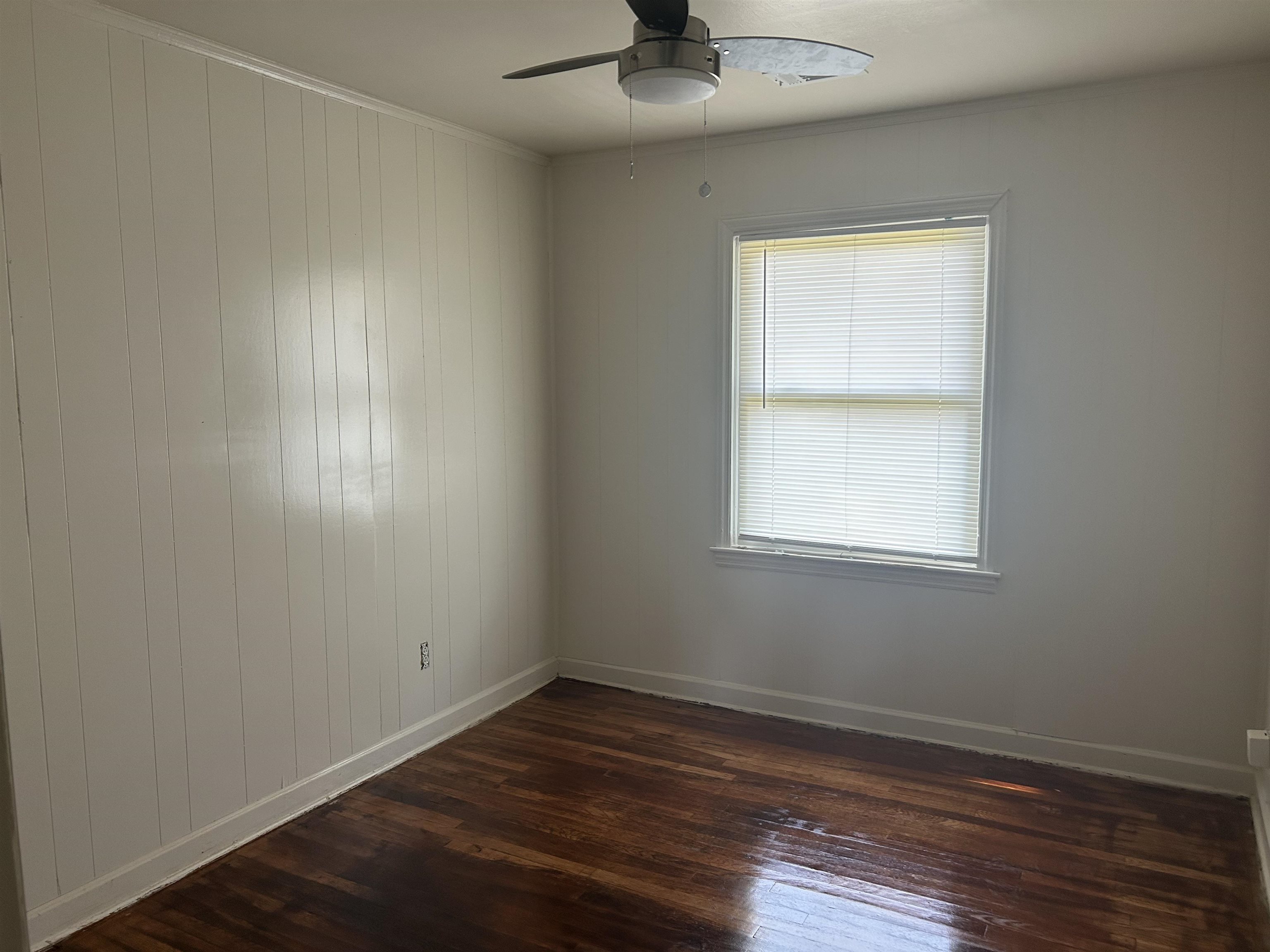 904 North Ball Road Memphis, TN 38106 - Photo 6 of 12 Room with wood-finish flooring, a window with blinds, a ceiling fan, and paneling on one wall
