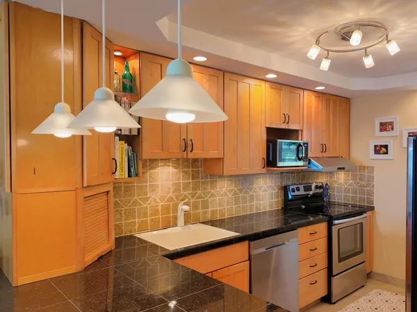 a view of a dining room with furniture a chandelier and large windows