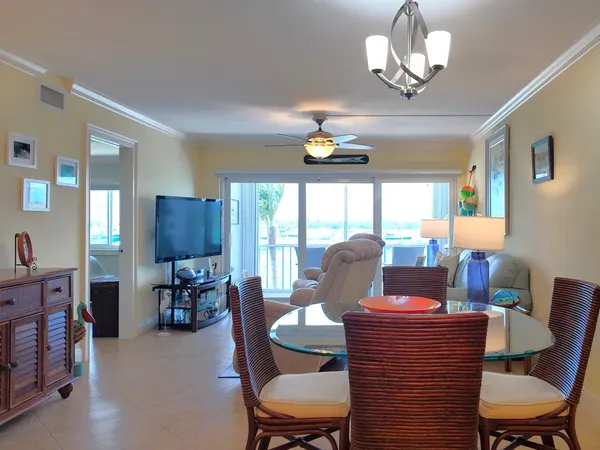 a view of a dining room with furniture a chandelier and wooden floor