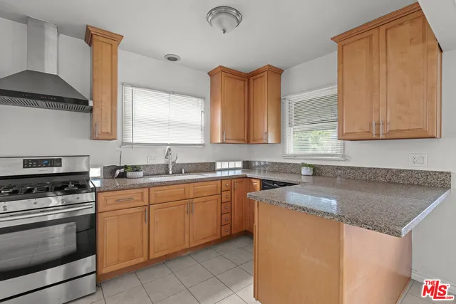a kitchen with granite countertop a sink stainless steel appliances and cabinets