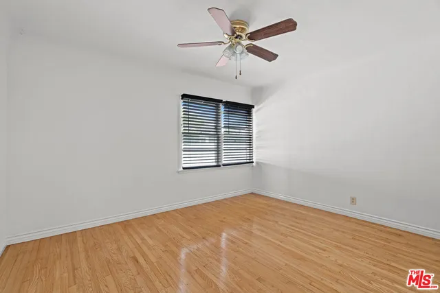 an empty room with a window and a fan
