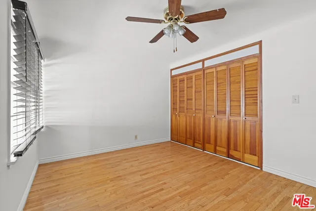 an empty room with fan and windows