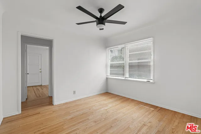 a view of a livingroom with wooden floor and a ceiling fan