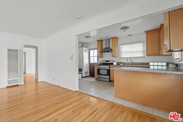 a kitchen with stainless steel appliances granite countertop a stove a sink and a refrigerator
