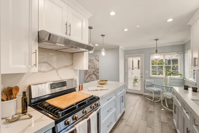 a kitchen with stainless steel appliances a stove a sink dishwasher and cabinets with wooden floor