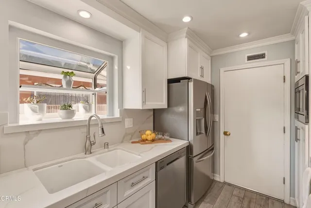 a kitchen with stainless steel appliances a refrigerator sink and cabinets