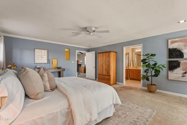 a spacious bedroom with a balcony a bed and a chandelier