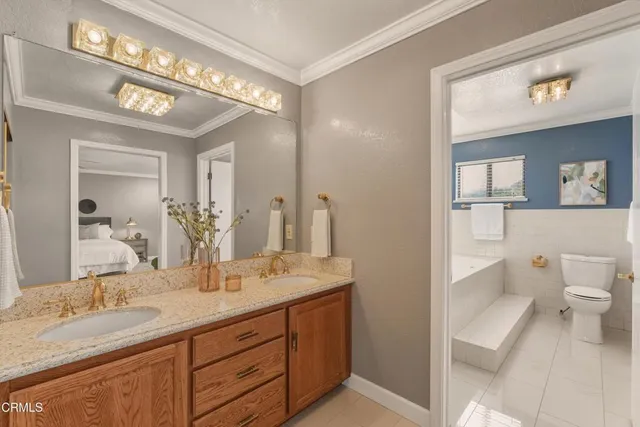 a bathroom with a granite countertop sink mirror and toilet