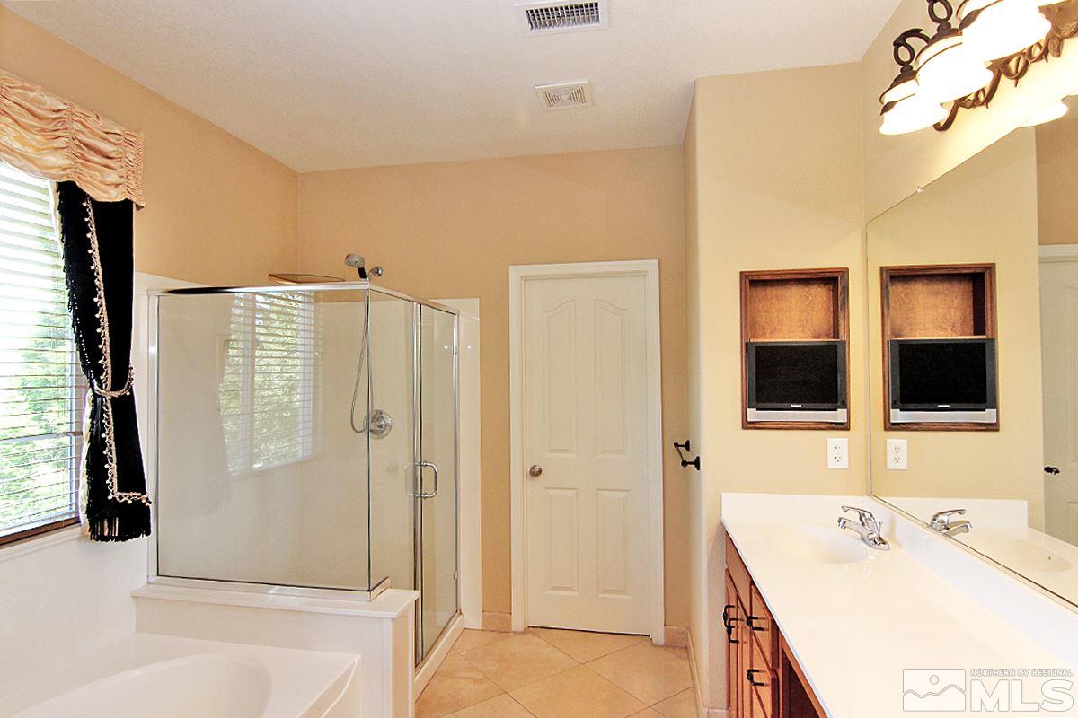 11205 Messina Way Reno, NV 89521 - Photo 28 of 40 a bathroom with a tub sink and a mirror