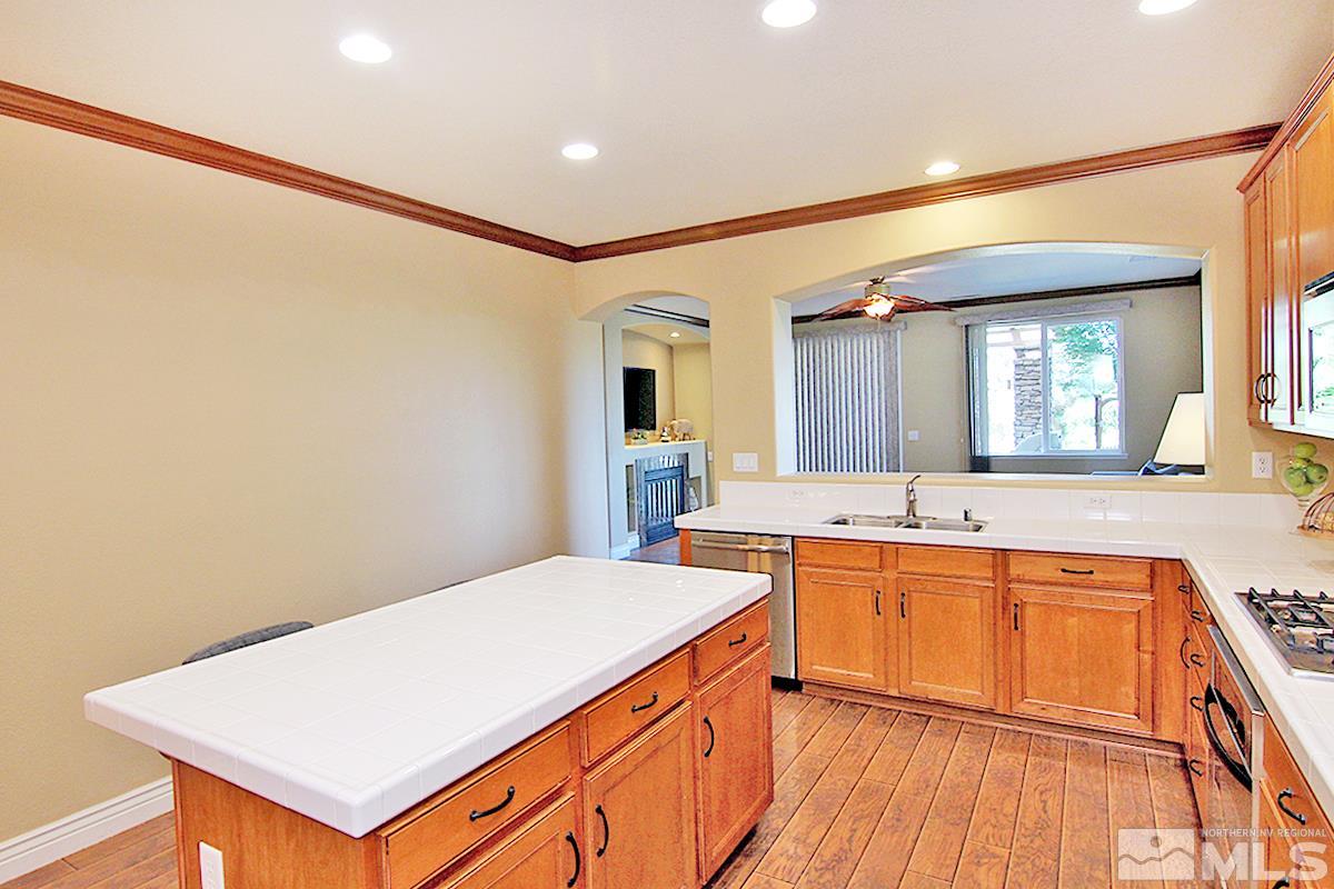 11205 Messina Way Reno, NV 89521 - Photo 9 of 40 a large kitchen with a sink and wooden floor