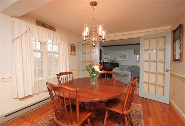 124 Miles River Road Hamilton, MA 01982 - Photo 9 of 22 a dining room with furniture a chandelier and wooden floor