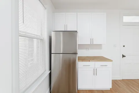 a white refrigerator freezer and a wooden floor
