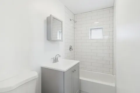 a bathroom with a bathtub a sink a toilet and a mirror