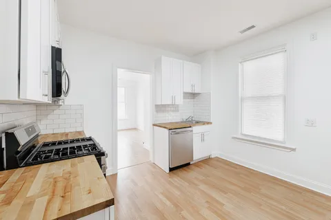 a kitchen with wooden floor and a stove top oven