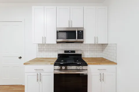 a kitchen with microwave cabinets and stove top oven